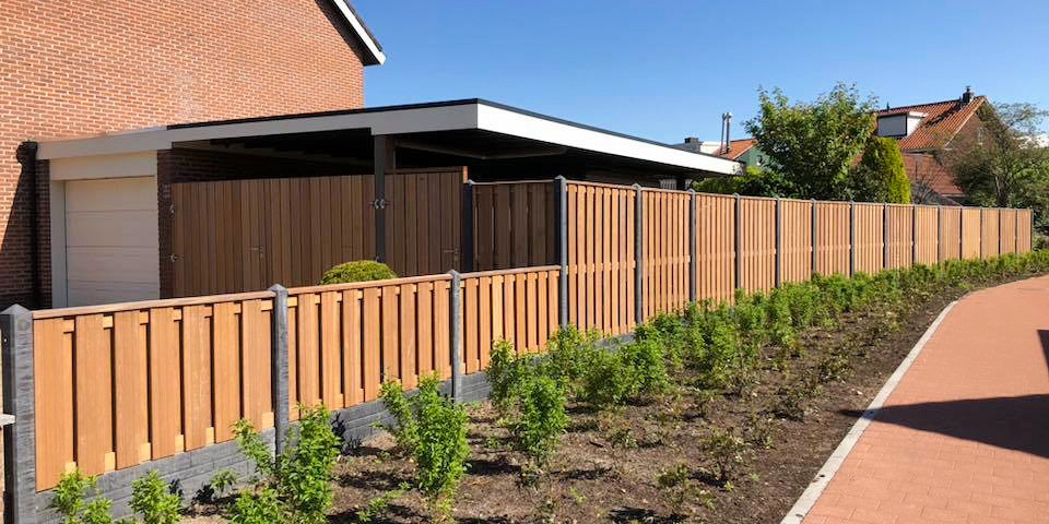 Lange houten schutting met betonnen staanders